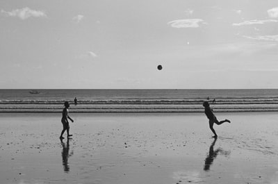 两个孩子在沙滩上玩耍的灰度照片